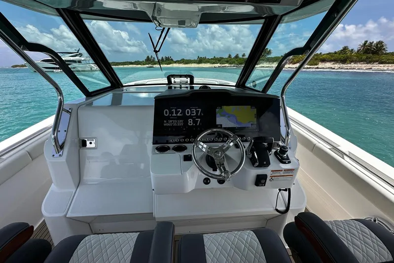  Yacht Photos Pics 2022 Bertram 39 CC boat cockpit with modern navigation system, steering wheel, and ocean view.