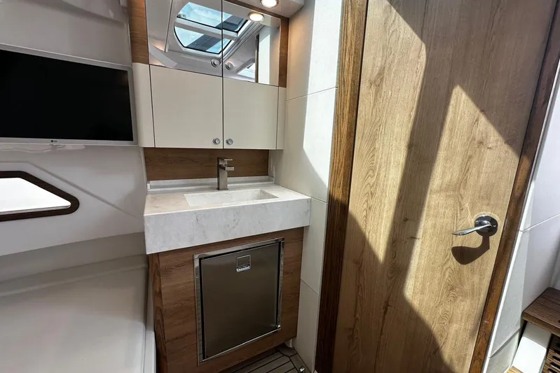  Yacht Photos Pics Interior of 2022 Bertram 39 CC yacht featuring modern sink, cabinetry, and wood accents.