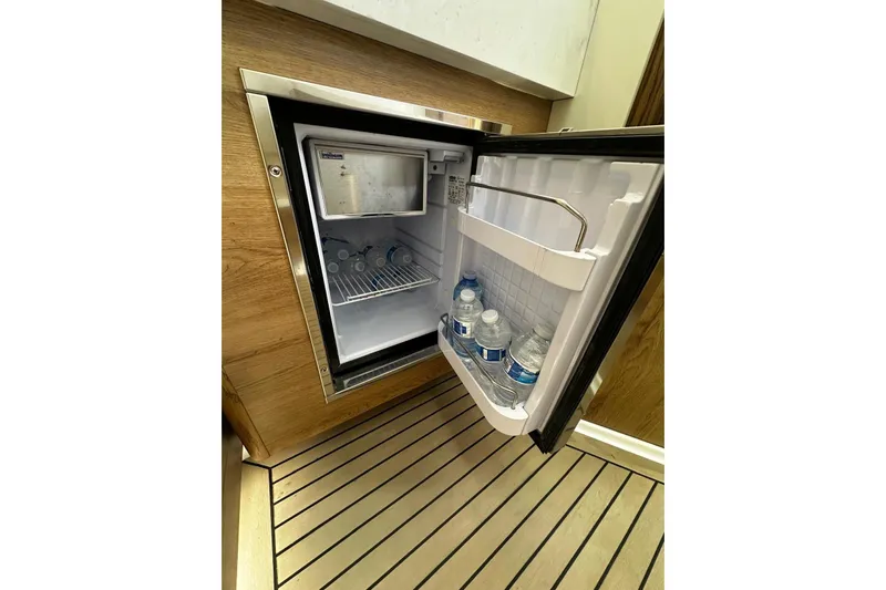  Yacht Photos Pics Mini fridge on 2022 Bertram 39 CC boat, stocked with water bottles.