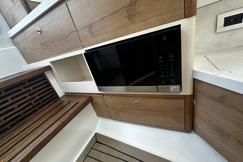  Yacht Photos Pics 2022 Bertram 39 CC interior with wood cabinetry and built-in microwave.