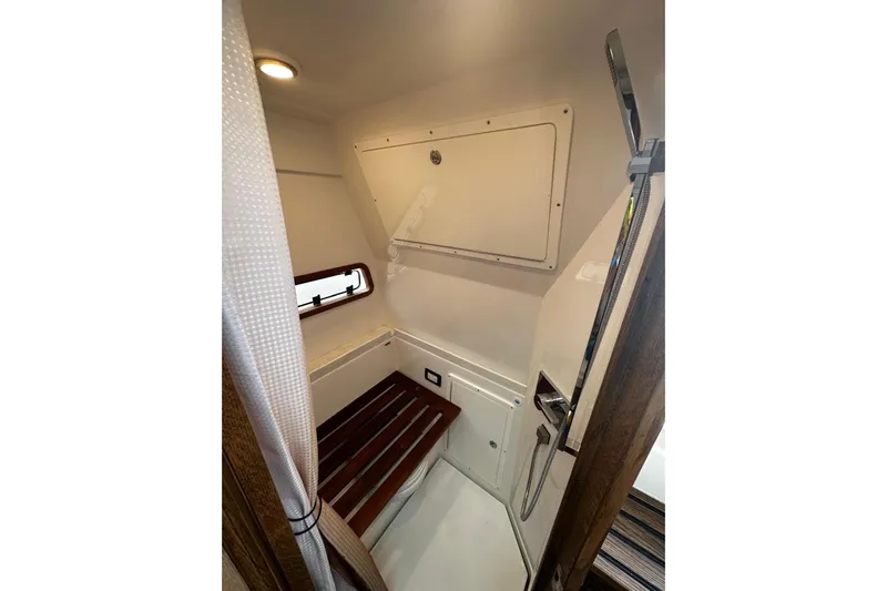  Yacht Photos Pics 2022 Bertram 39 CC boat interior with shower and wooden bench.