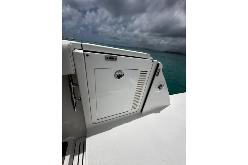  Yacht Photos Pics 2022 Bertram 39 CC boat detail with storage compartment, ocean backdrop, and cloudy sky.