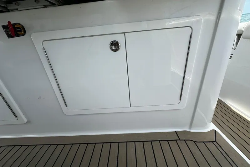  Yacht Photos Pics 2022 Bertram 39 CC boat storage compartment with sleek white finish and secure lock.