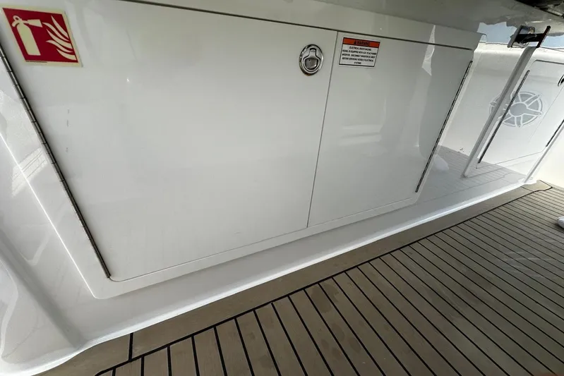  Yacht Photos Pics 2022 Bertram 39 CC boat deck with storage compartment and fire extinguisher sign.