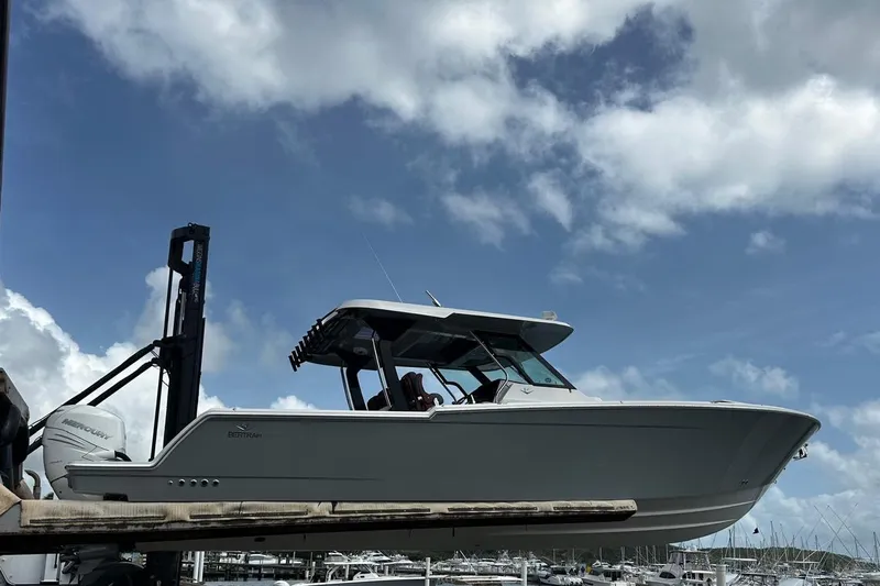 Yacht Photos Pics 2022 Bertram 39 CC boat on lift against cloudy sky background.