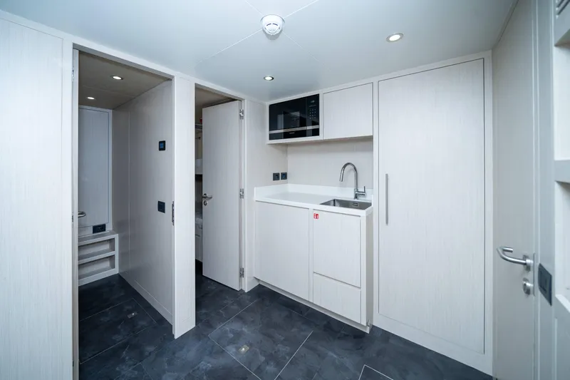  Yacht Photos Pics Modern interior of 2024 Nomad 75 SUV with sleek cabinetry and compact kitchenette.