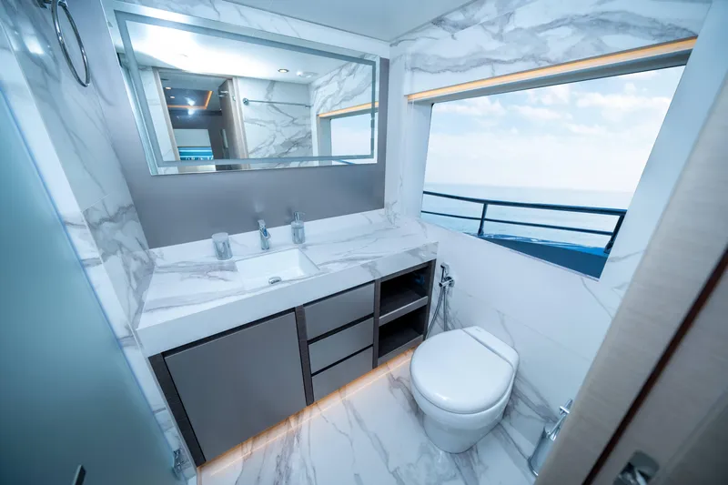  Yacht Photos Pics Luxurious bathroom in 2024 Nomad 75 SUV yacht with marble decor and ocean view.
