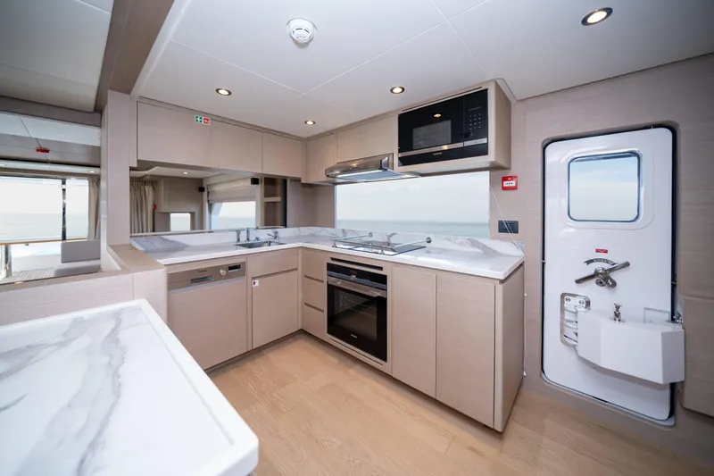  Yacht Photos Pics Modern kitchen interior in 2024 Nomad 75 SUV yacht, featuring sleek design and appliances.