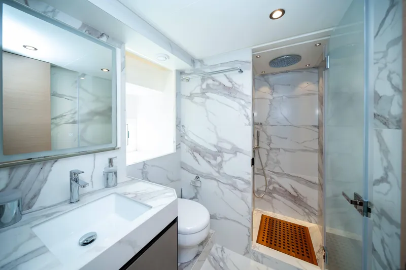 Yacht Photos Pics Luxurious marble bathroom in 2024 Nomad 75 SUV with modern fixtures and spacious shower.