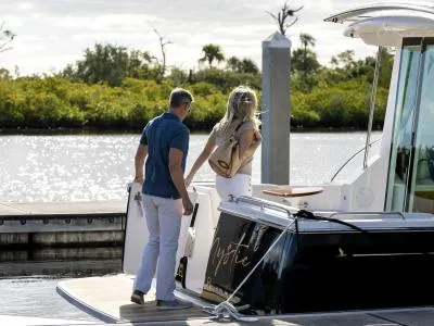 Call For Availability Yacht Photos Pics Couple boarding 2025 Back Cove 372 yacht at a sunny marina.