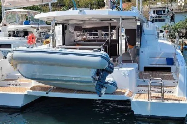 Mirabella Yacht Photos Pics 2022 Bali 4.2 catamaran with dinghy, docked at marina, showcasing spacious deck and modern design.