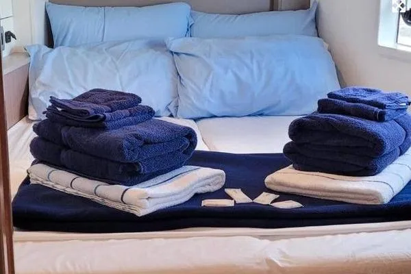 Mirabella Yacht Photos Pics Luxurious Bali 4.2 yacht bedroom with neatly arranged blue towels, 2022 model.