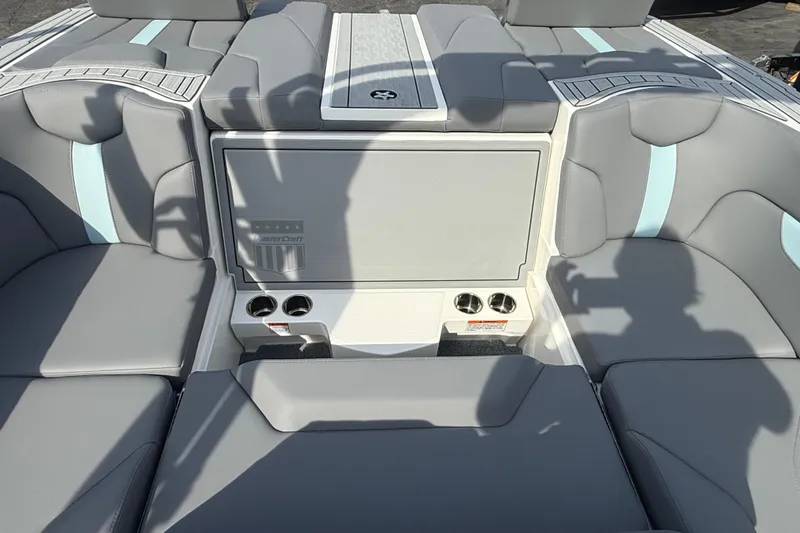  Yacht Photos Pics 2026 MasterCraft XT24 boat interior with gray and blue seating, cup holders, and storage compartment.