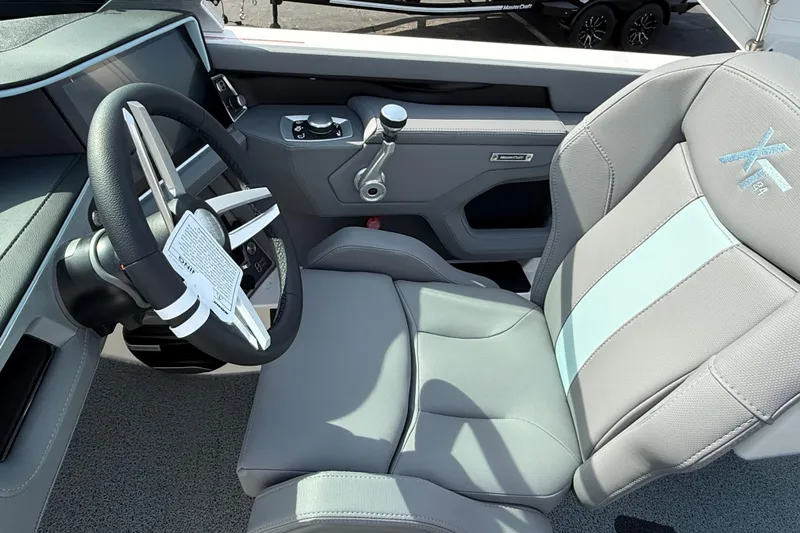  Yacht Photos Pics 2026 MasterCraft XT24 boat interior with steering wheel and captain's seat.