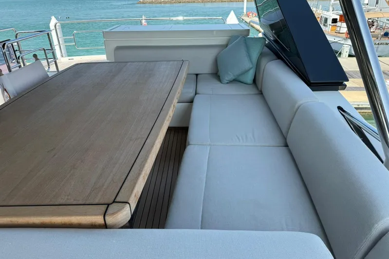  Yacht Photos Pics Luxurious seating area on 2019 Monte Carlo Yachts MCY 70 with wooden table and cushions.