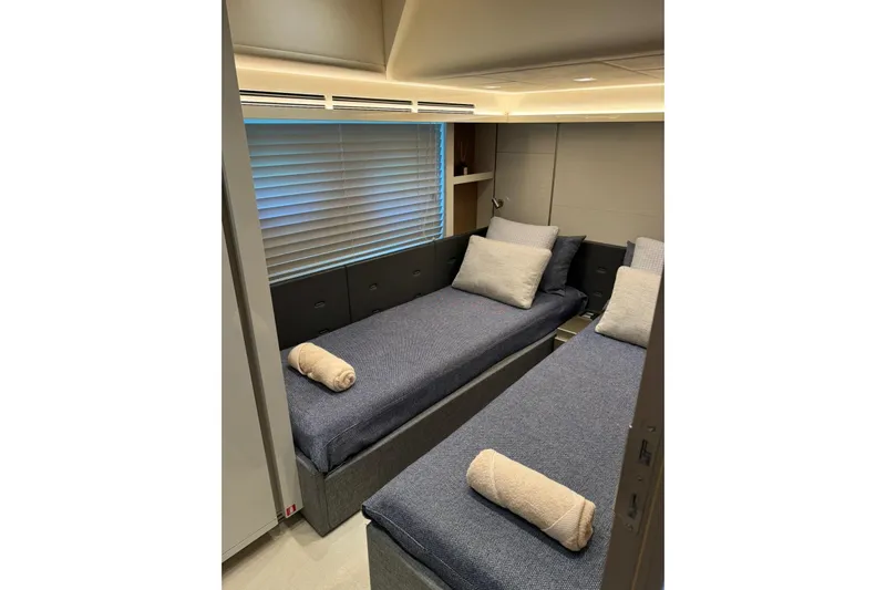  Yacht Photos Pics Luxurious twin cabin in 2019 Monte Carlo Yachts MCY 70, featuring modern decor and cozy bedding.