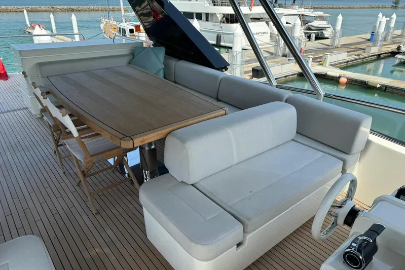  Yacht Photos Pics Luxurious seating area on 2019 Monte Carlo Yachts MCY 70, featuring elegant wooden table.