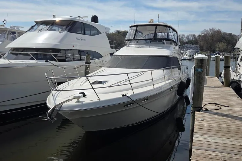  Yacht Photos Pics 2002 Sea Ray 560 Sedan Bridge yacht docked at marina, side view.