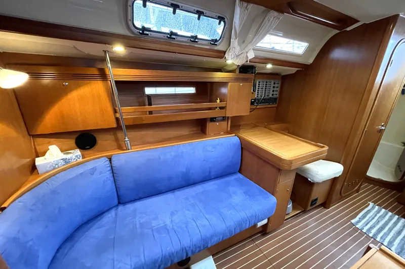 New Journey Yacht Photos Pics Interior of 2005 Dufour 40 Performance yacht with blue sofa and wooden cabinetry.