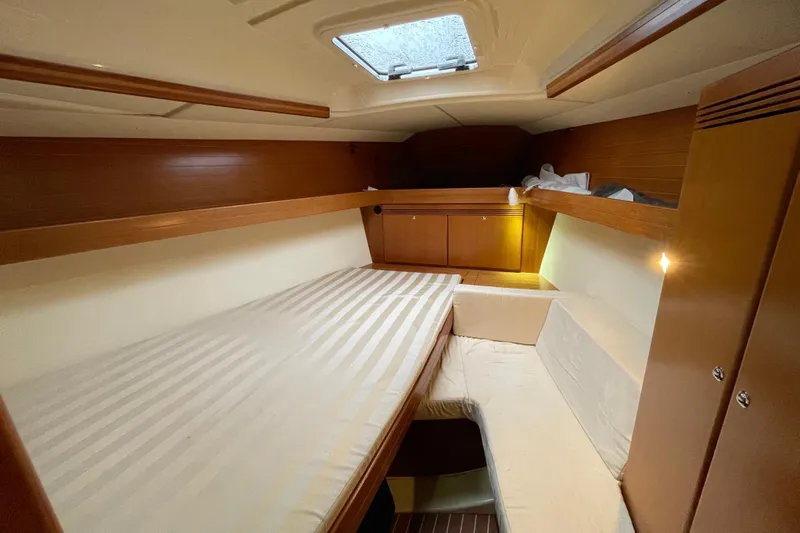 New Journey Yacht Photos Pics Cozy cabin interior of 2005 Dufour 40 Performance yacht with wooden accents and bedding.