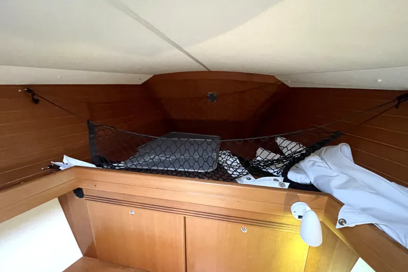 New Journey Yacht Photos Pics Interior storage area of 2005 Dufour 40 Performance sailboat with netting and wooden finish.