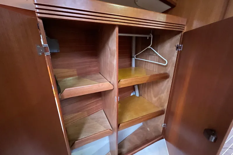 New Journey Yacht Photos Pics Wooden closet interior with shelves and hanger in 2005 Dufour 40 Performance yacht.