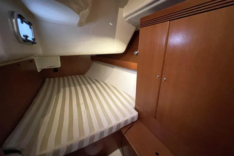 New Journey Yacht Photos Pics Cozy cabin interior of 2005 Dufour 40 Performance sailboat with striped bedding.