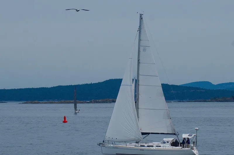 New Journey Yacht Photos Pics Sailing yacht Dufour 40 Performance 2005 on calm waters with distant hills.