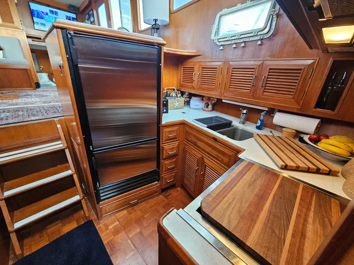 Kolea Yacht Photos Pics 1983 Ocean Alexander 43 yacht kitchen with wood cabinetry and stainless steel appliances.