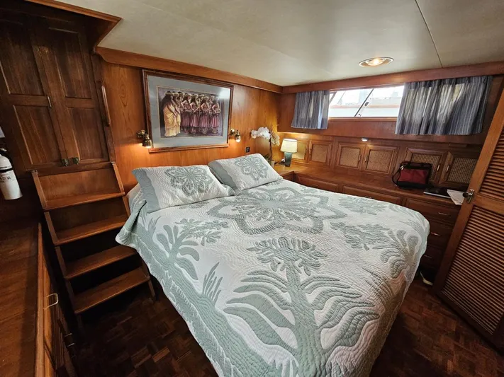 Kolea Yacht Photos Pics Luxurious 1983 Ocean Alexander 43 yacht bedroom with elegant wood paneling and cozy bedding.