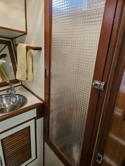 Kolea Yacht Photos Pics 1983 Ocean Alexander 43 bathroom with sink, towel, and textured glass door.