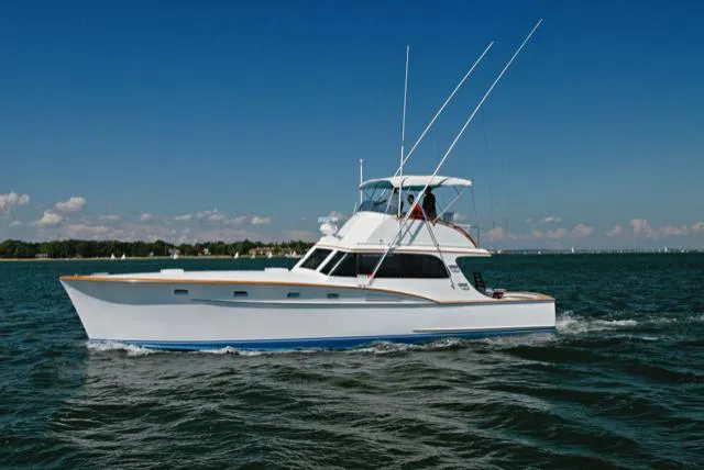 Proud Lady Yacht Photos Pics 1957 Rybovich Convertible yacht cruising on open water under clear blue skies.