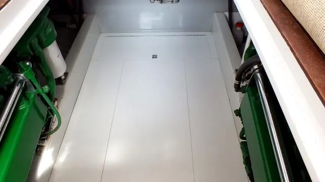 Proud Lady Yacht Photos Pics Engine room of a 1957 Rybovich Convertible boat, featuring green machinery and clean white surfaces.