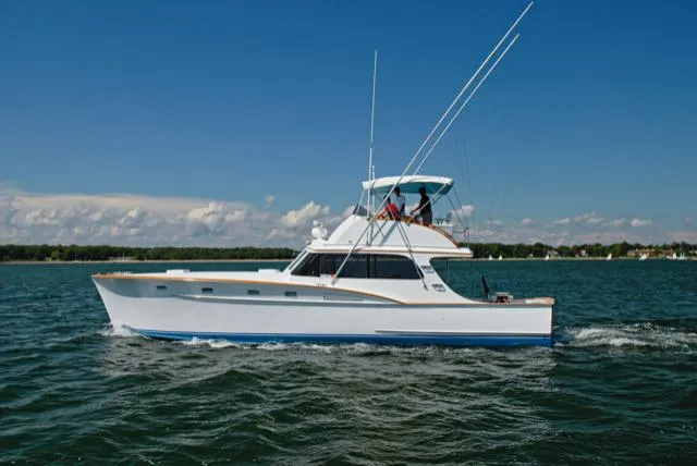 Proud Lady Yacht Photos Pics 1957 Rybovich Convertible yacht cruising on open water under clear blue skies.
