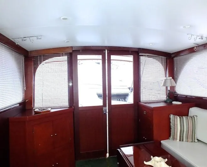 Proud Lady Yacht Photos Pics Interior of a 1957 Rybovich Convertible yacht with wooden paneling and blinds.