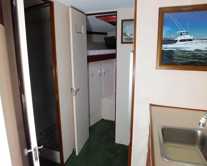 Proud Lady Yacht Photos Pics 1957 Rybovich Convertible interior with sink, cabinets, and framed boat picture.
