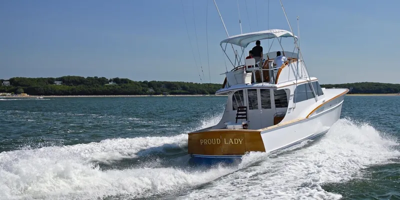 Proud Lady Yacht Photos Pics 1957 Rybovich Convertible boat cruising on open water, named "Proud Lady."