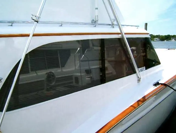 Proud Lady Yacht Photos Pics 1957 Rybovich Convertible boat with sleek design and polished wood accents docked by the water.