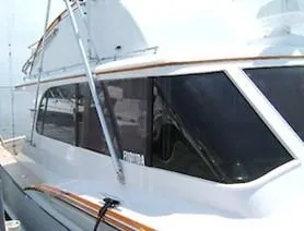 Proud Lady Yacht Photos Pics 1957 Rybovich Convertible boat with sleek design and large windows at a dock.