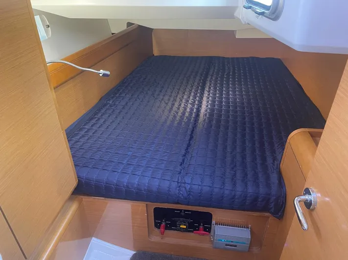  Yacht Photos Pics Cozy cabin interior of 2011 Jeanneau Sun Odyssey 439 with a neatly made bed.