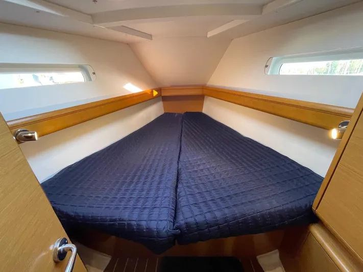  Yacht Photos Pics Cozy cabin interior of 2011 Jeanneau Sun Odyssey 439 sailboat with a neatly made bed.
