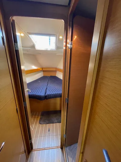  Yacht Photos Pics Interior cabin of 2011 Jeanneau Sun Odyssey 439 sailboat, featuring cozy bed and wooden finish.