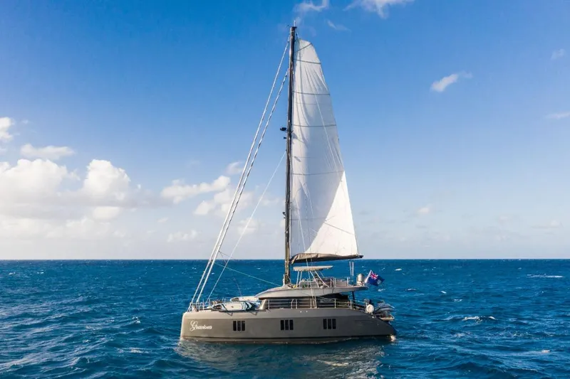 Gracious Yacht Photos Pics 2021 Sunreef 60 yacht sailing on open ocean under clear blue sky.