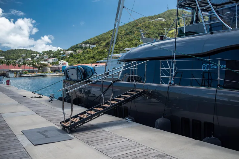 Gracious Yacht Photos Pics Luxury Sunreef 60 yacht docked at marina, 2021 model, with scenic hillside backdrop.