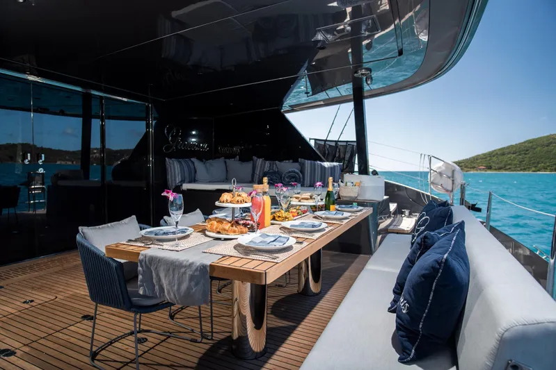 Gracious Yacht Photos Pics Luxurious Sunreef 60 yacht deck with elegant dining setup, ocean view, and plush seating.