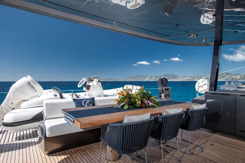Gracious Yacht Photos Pics Luxurious Sunreef 60 yacht deck with dining area, ocean view, and elegant seating, 2021 model.