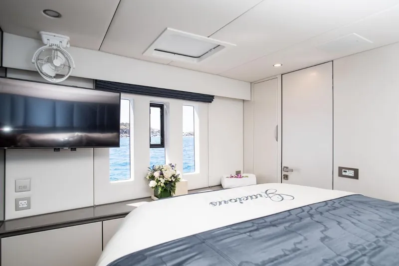 Gracious Yacht Photos Pics Luxurious Sunreef 60 yacht bedroom with ocean view, TV, and elegant decor, 2021 model.