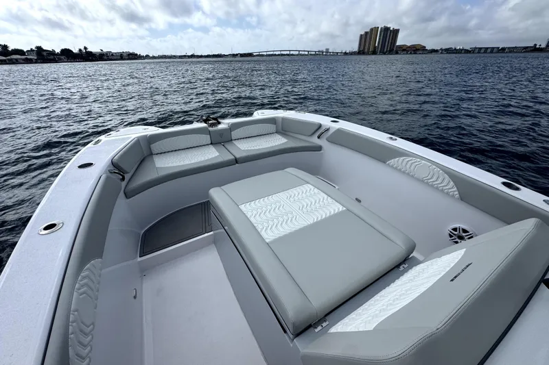  Yacht Photos Pics 2026 Twin Vee 280 GFX2 CC boat interior with cushioned seating on calm water.