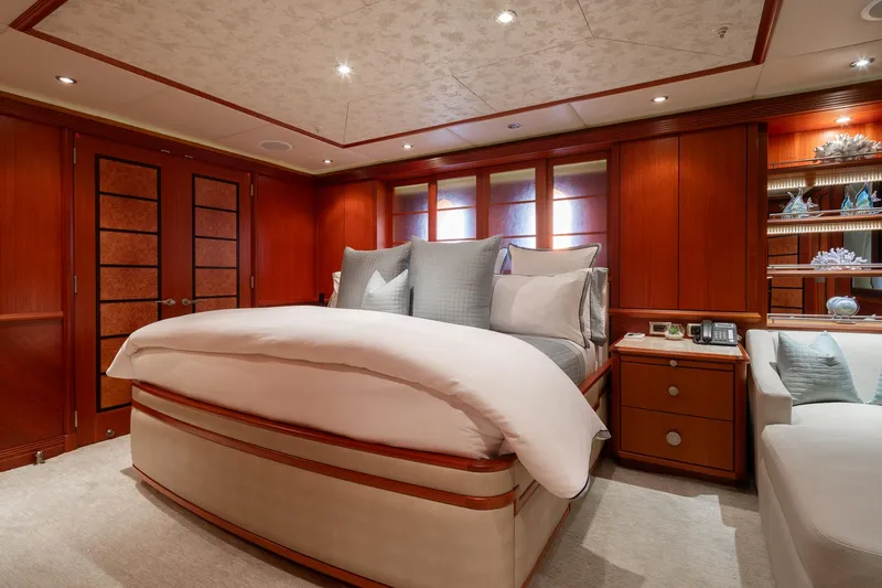 Skyfall Yacht Photos Pics Luxurious bedroom interior on 2010 Trinity Yachts motor yacht, featuring elegant wood paneling and plush bedding.