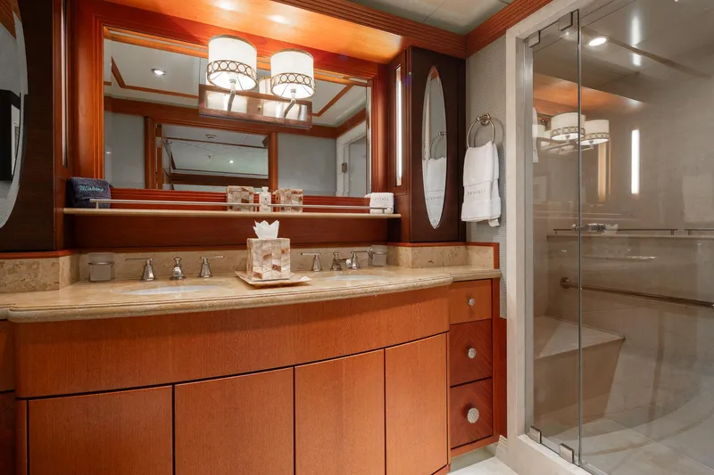 Skyfall Yacht Photos Pics Luxurious bathroom in 2010 Trinity Yachts motor yacht with elegant wood cabinetry and glass shower.